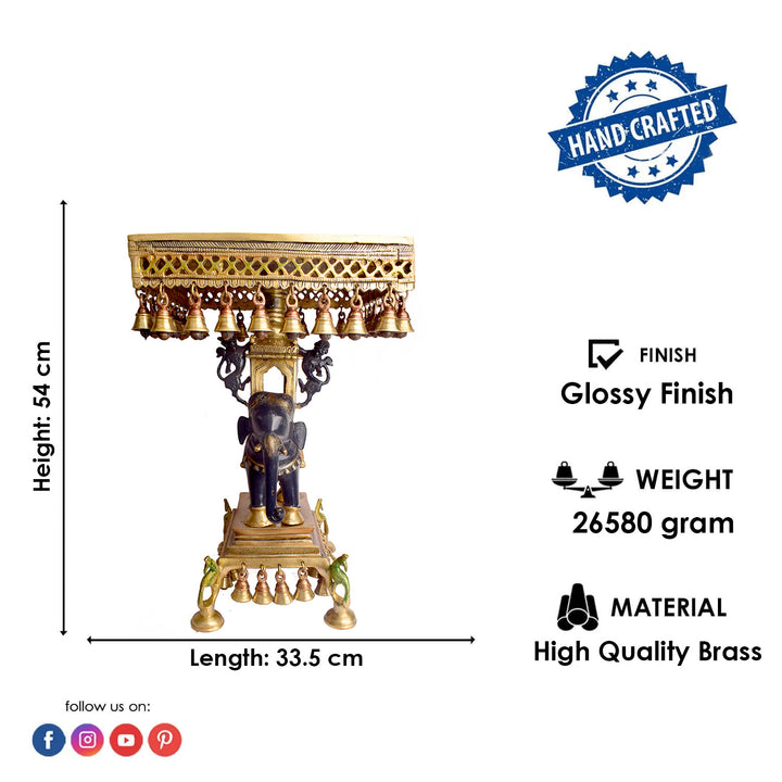 Large Brass Idol of 23 Inch Brass Chowki on Elephant with Hanging Bells. This 23 Inch Brass Chowki on Elephant with Hanging Bells is a stunning blend of artistry and tradition. Crafted from high-quality brass, the intricate detailing of the elephant and the delicately suspended bells add a touch of elegance to any space. 